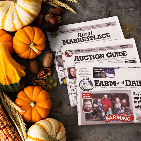 Pumpkins and nuts surrond a copy of the Farm and Dairy Newspaper
