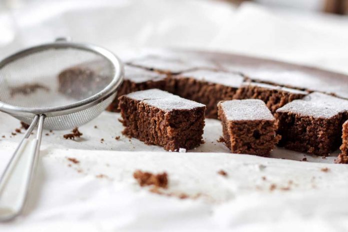 Black Forest Passover Brownies being dusted with powdered sugar.