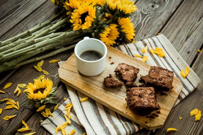 Cinnamon Brownies Cinnamon Brownies on a cutting board with a cup of coffee and sunflowers on the table.