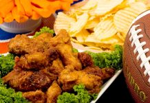 Parmesan Chicken Wings Parmesan Wings with Super Bowl party snacks and a football in the background.