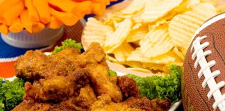 Parmesan Wings with Super Bowl party snacks and a football in the background.