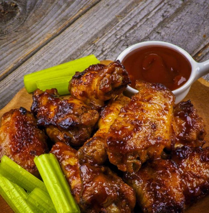 Raspberry Barbecue Wings Raspberry Barbecue Wings with extra sauce and celery on the side.