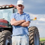 Eight pilot communities will build links between farmers and consumers Farmer standing by tractor