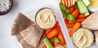 Hummus packed with fruits and vegetables for a school lunch.