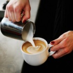 pouring creamer into coffee