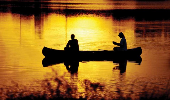 two men fishing in a canoe
