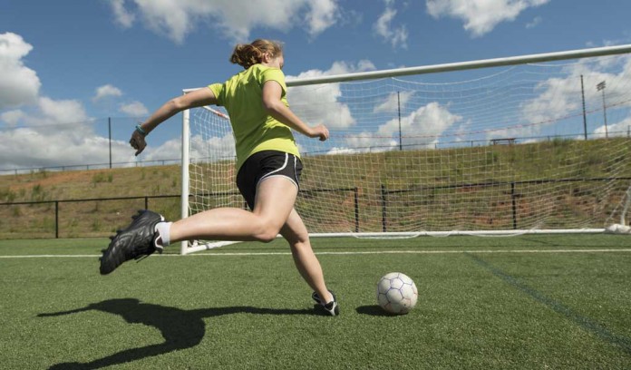 girl kicking soccer ball into goal girl kicking soccer ball into goal