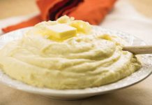 Cheesy Maple Mashed Potatoes A serving bowl of Cheesy Maple Mashed Potatoes with a pat of butter on top.