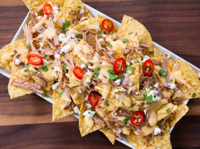 Pulled Pork Nachos Nachos covered in pulled pork, cilantro, peppers, cheese and other yummy toppings.