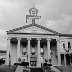 The tall clock tower and looming white pillars of the Lawrence County, Pennsylvania Courthouse stands tall against the cloudy sky as another day in Drug Court begins.