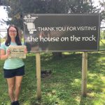 Visiting The House of the Rock with Lisa Kalas Lisa Kalas holding the Farm and Dairy Newspaper standing next to a sign that reads "Thank You For Visiting The House of the rock" in Madison, Wisconsin