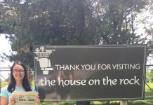 Visiting The House of the Rock with Lisa Kalas Lisa Kalas holding the Farm and Dairy Newspaper standing next to a sign that reads "Thank You For Visiting The House of the rock" in Madison, Wisconsin