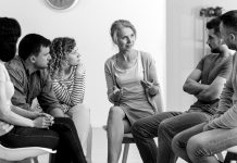 Where to get help A diverse group of people sit and talk during a group counseling session.
