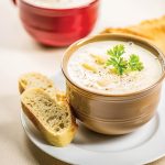 Two bowls of potato soup sit waiting to be eaten.