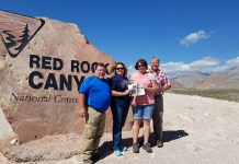 Hiking in the Red Rock with the Bates and Tracy families The Bates and Tracy Families pose in front of the entrance for Red Rock Canyon National Park with the Farm and Dairy paper in hand.
