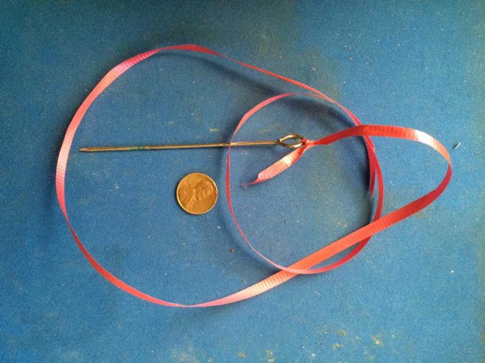 hazard_darwin Antique pin about 6 inches long with a large rounded opening at the one end.