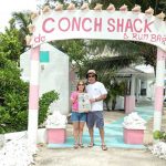 The Willoughbys took us to Turks and Caicos! The Willoughbys at the entrance to Da Conch Shack on Turks and Caicos holding a Farm and Dairy Newspaper