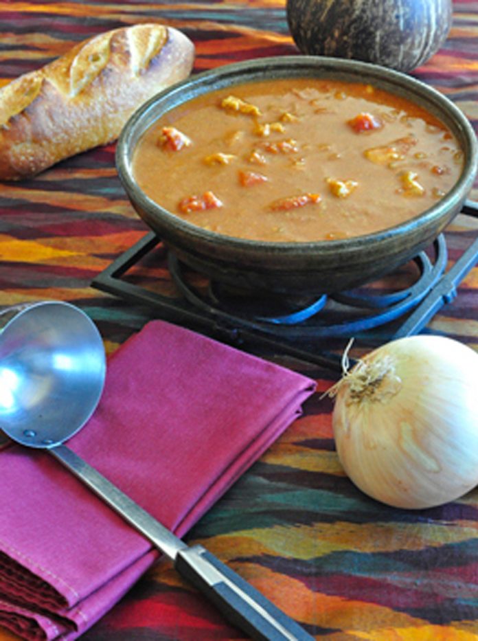 West African Peanut Soup A bowl of West African Peanut Soup with an onion, and ladel in the foreground