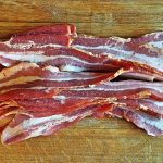W.Va. man charged with felony over bacon theft Bacon layed out on a cutting board to be chopped into pieces for Pigskin Bites