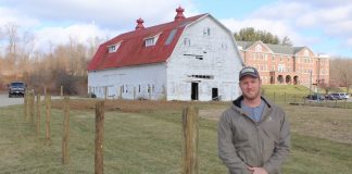 John Lindsey, an FFA adviser at New Lexington, standing in front of school farm.