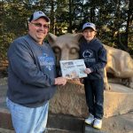 Visiting the Penn State with the Halls Dennis Hall standing in front of the Nitany Lion Statue at Penn State with his nephew, Jake and his Farm and Dairy.