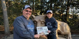 Dennis Hall standing in front of the Nitany Lion Statue at Penn State with his nephew, Jake and his Farm and Dairy.