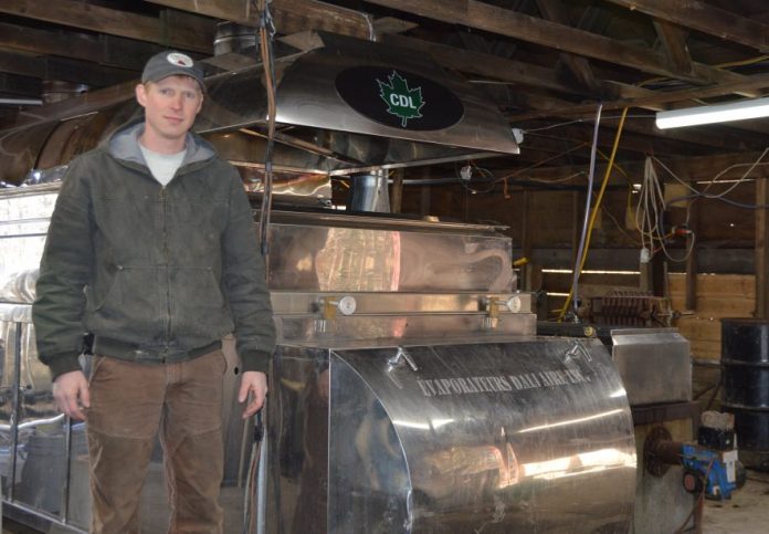 Nathan Goodell standing by their evaporator. maple syrup, Ohio farm