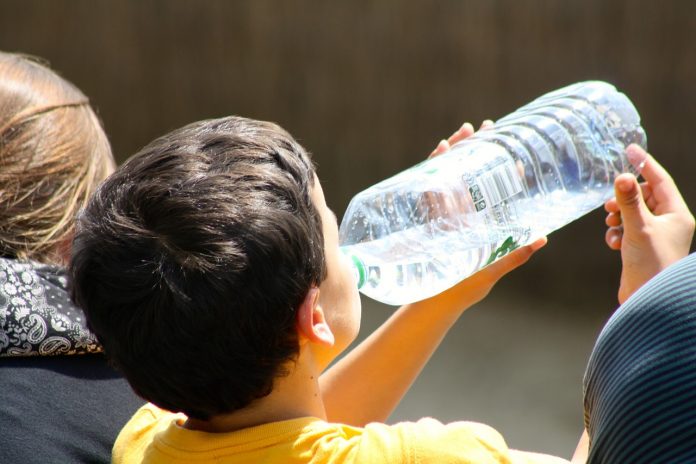 boy drinking from water bottle boy drinking from water bottle