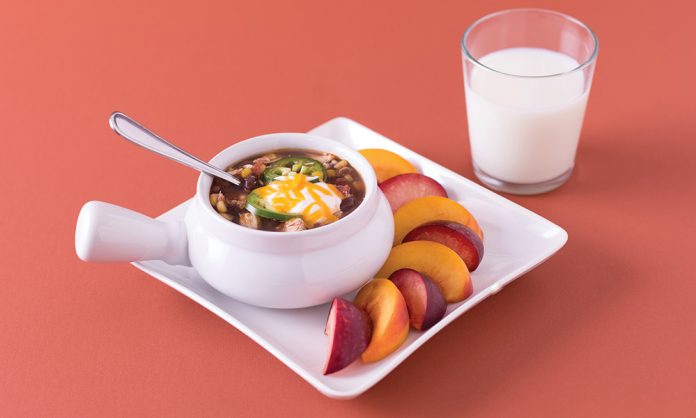 A bowl of Slow Cooker Mexican Chicken Soup a bowl of Slow Cooker Mexican Chicken Soup, served with apple slices and a glass of milk.