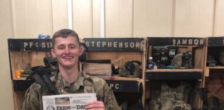 Pfc. Sims poses with his farm and dairy in front of his machine gun while on deployment in Afghanistan