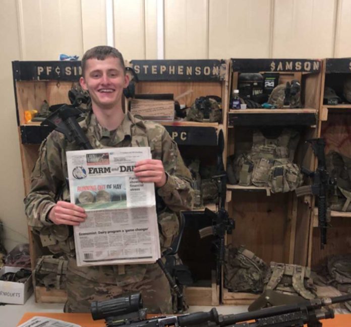 Pfc. Sims poses with his farm and dairy in front of his machine gun while on deployment in Afghanistan