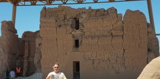 Bill Henry stands in front of the Casa Grande Ruins holding a Farm and Dairy newspaper.