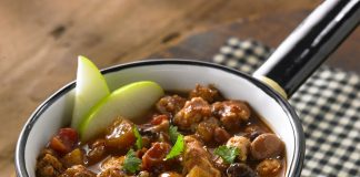 A bowl of Apple Turkey Chili garnished with two apple slices.