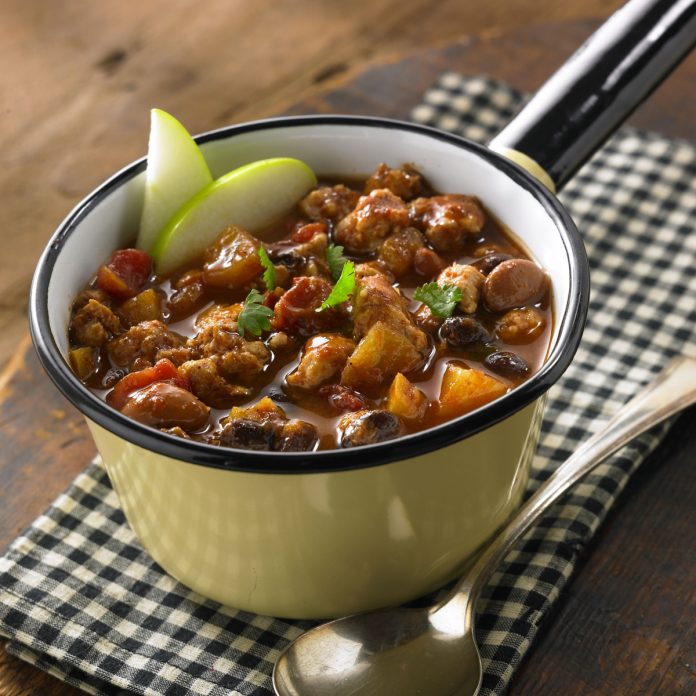 A bowl of Apple Turkey Chili garnished with two apple slices.