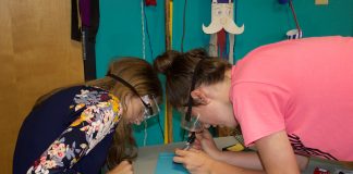4-H'ers work on a soldering activity at a club meeting.