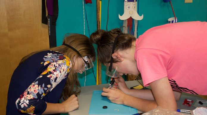 Breaking the cycle of limited broadband access, knowledge 4-H'ers work on a soldering activity at a club meeting.