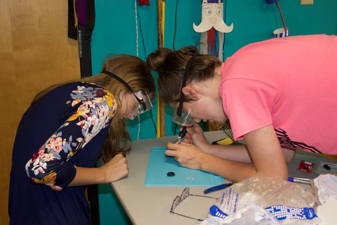 4-H'ers work on a soldering activity at a club meeting.