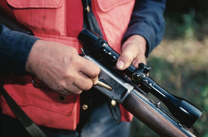 hunter loading rifle orange vest