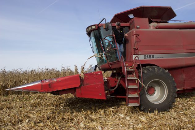 A farmer climbs out of a combine.