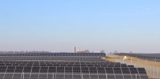 How a rural Ohio town is leading the way in clean energy solar panels sit in a field with a barn and silo in the background