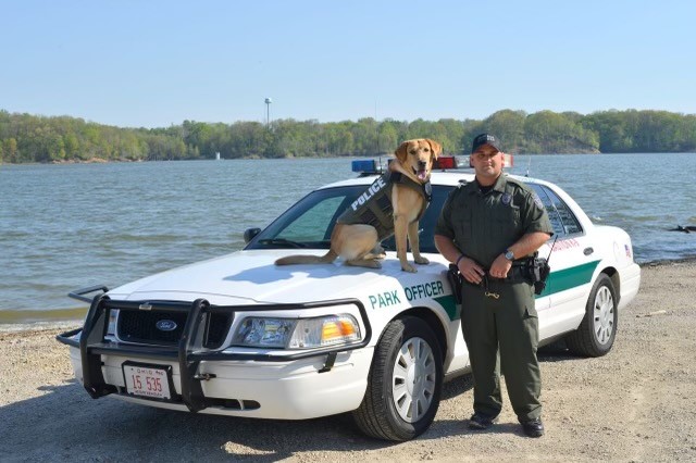 Ranger 5 An ODNR officer and K-9 stand in front of a car.