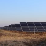solar panels sit behind a fence