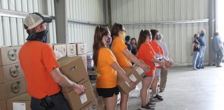 volunteers hold boxes of food