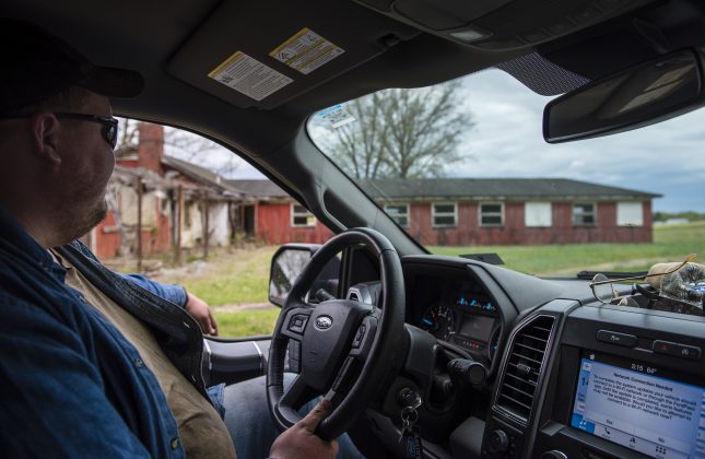 A man drives past a former prison on his family farm.