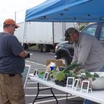W.Va. farmers market a way for local farmers to grow together A farmer serves a customer at a farmers market.