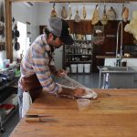 Hand Hewn Farm finds niche in hog butchering workshops guy wrapping up meat on a table