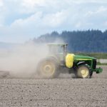 ‘Climate is a test; if we pass, we get to keep Earth’ tractor stirring up dust in a field