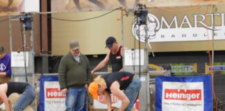 Ohio teen wins national shearing contest a man shears a sheep on a stage