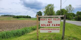 Solar debate hits western Pennsylvania farming communities a sign reading roofs not fields no solar farm sits along a road with farm fields in the background