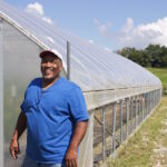 South Side Family Farms explores food justice through farming a man stands next to a high tunnel